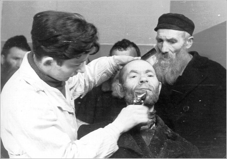 A barber cutting a Jew's beard in the Radom ghetto.